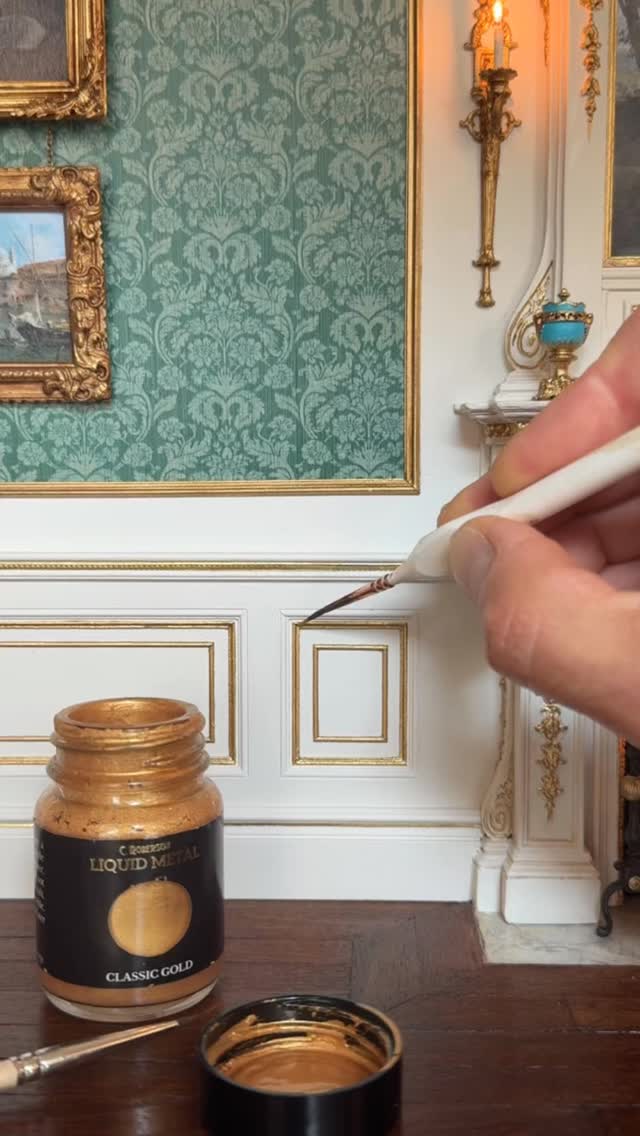 Welcome back to Episode 4 - My journey creating period panelling in this 1:12 scale Georgian room box!
I started by designing the framework for the panels and laser-cutting them from 2mm MDF. I used miniature wood mouldings, these were mitred and glued into place, the skirting board and decorative chair rail were sourced from @dollshousemouldings 
Once all the panelling was constructed, it was primed and painted using @duluxheritage Flax Seed 🤍👌🏻
I then gilded the inner mouldings using Liquid Metal gold paint mixed with metallic bronze powder in Pale Gold, both from the wonderful @l.cornelissen_and_son 🖌️🎨 I’d say this combination is just as effective as using gold leaf once mixed together! 💛
The beautifully detailed strips on the chair rail and skirting board are Dresden trims from @dresdner_pappen - Check out their Etsy shop for these and many other incredible decorative details — perfect for miniaturists! 🤩

Once everything was painted, all of the panels were installed. For the upper panels that resemble silk, I used a wallpaper design I created myself. I applied it using Mod Podge as an adhesive, which worked perfectly for this project - I learned the hard way after several failed attempts!😫
For the frames surrounding these panels, I used resin mouldings created by my talented cousin - Check out his Etsy shop, ‘Making It Small’. 

After mitring the pieces and assembling the frames to the correct size, they were spray-painted with a red primer. They were then hand-painted with the same Liquid Metal and metallic bronze powder mixture to achieve a rich gold finish.
Finally, the frames were fixed into place - You have to hand it to the Georgians—they certainly knew how to decorate!

Let me know what you think of the finished result in the comments below 👇
• •
#dollhouseminiatures #dollhouse #miniature #miniart #handmade